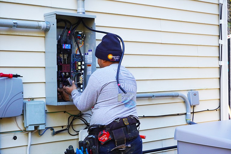 Electrician installing a transfer switch for a new whole-home generator