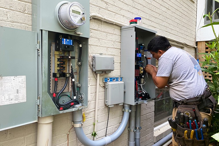 Electrician installing a transfer switch for a new whole-home generator