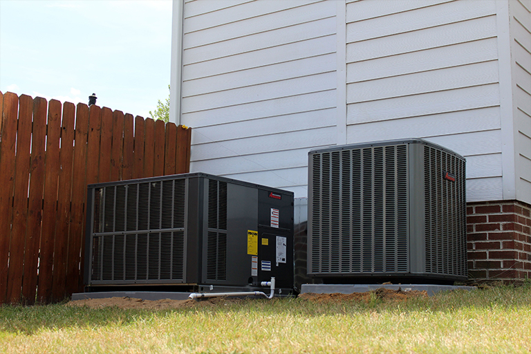 Newly installed packaged unit and heat pump outside a home