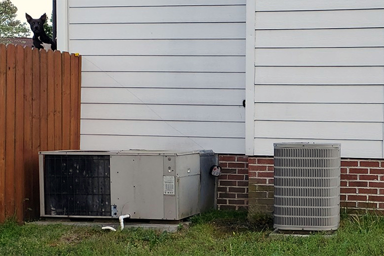 Old packaged unit and heat pump outside a home