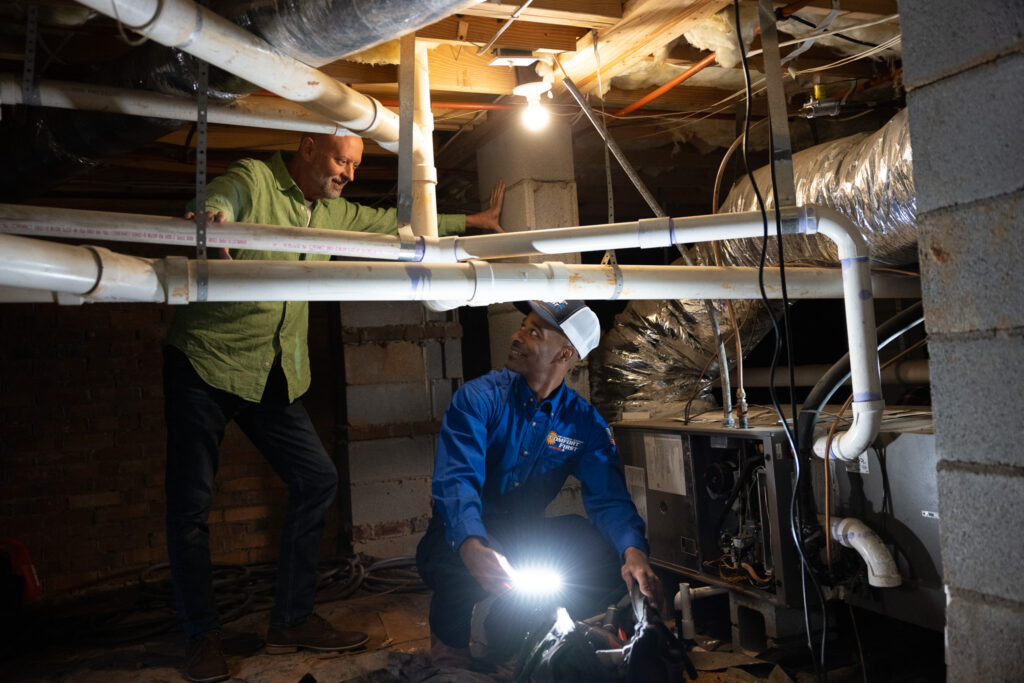 hvac tech working on heating system