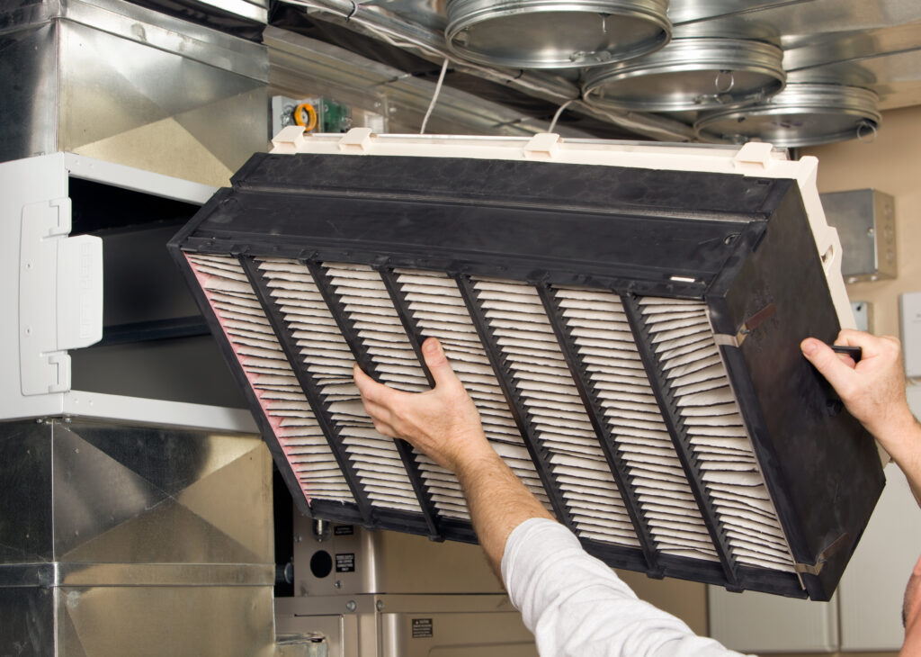 Whole-house air purifier being inserted by professional