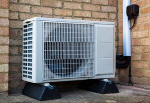 A single heat pump outside a modern house to provide air conditioning or warmth